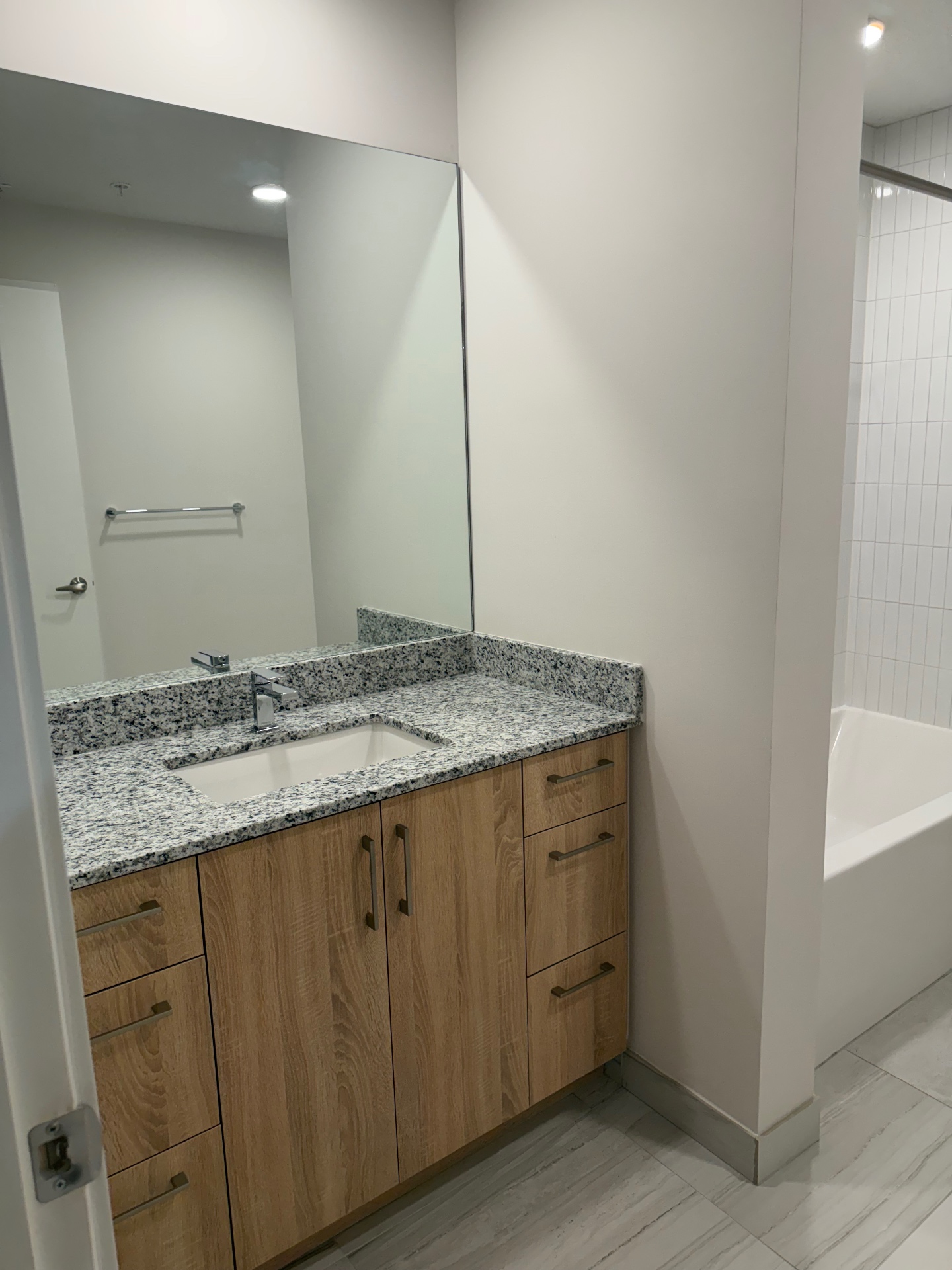 Clean bathroom vanity, mirror and bathtub
