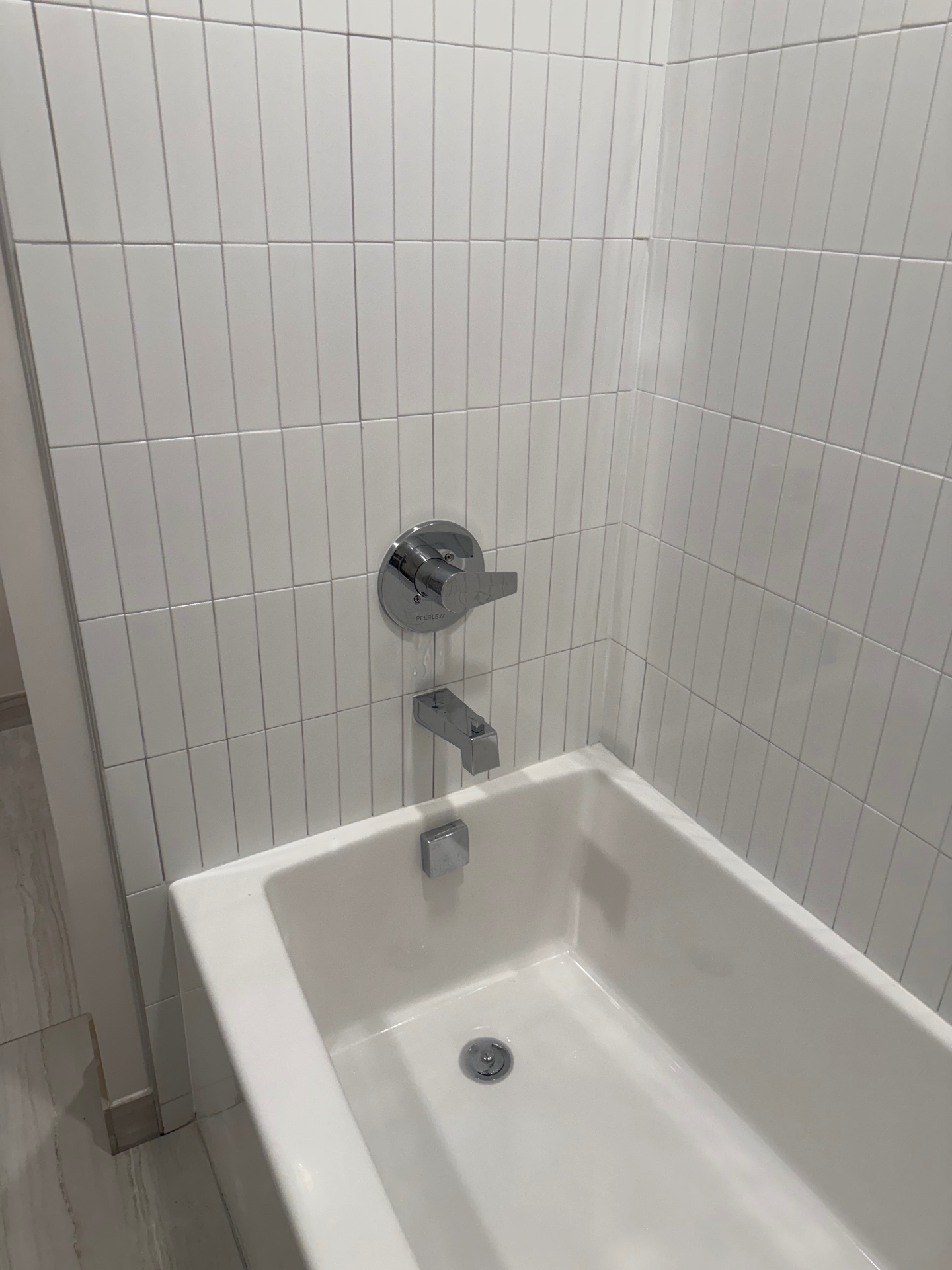 Clean white bathtub and tiled surround